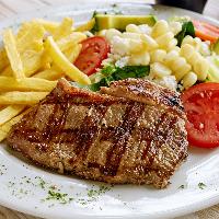 Bife a la parrilla con papas y guarnición de ensalada